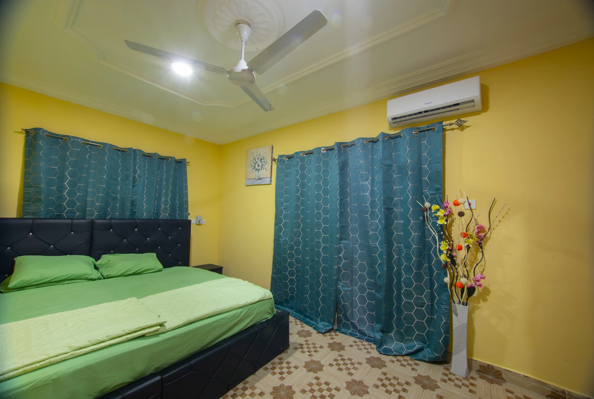 Closer view of the Sarpomaa Cottage bedroom with patterned curtains and air conditioning