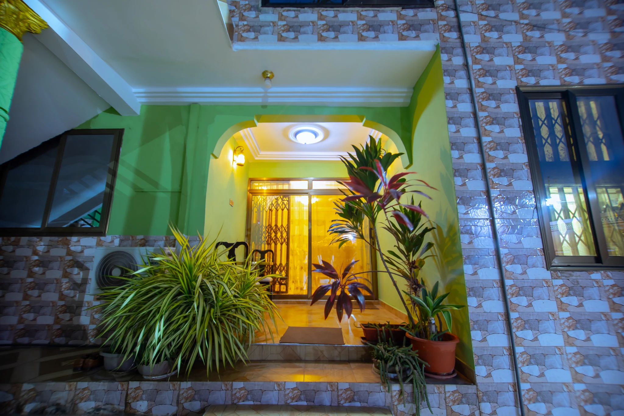 Lit entrance to Sarpomaa Cottage surrounded by plants