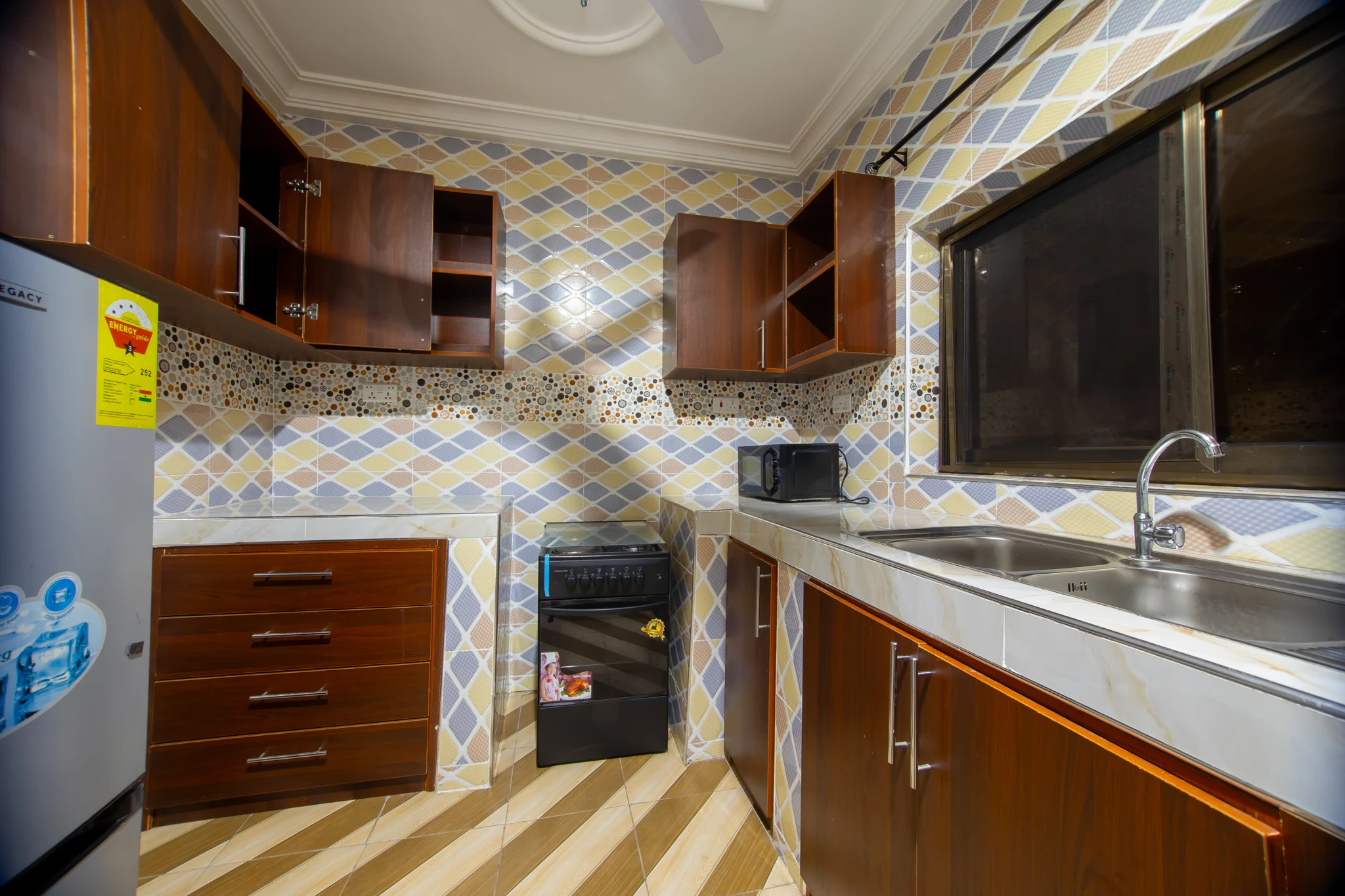 Kitchen at Sarpomaa Cottage with refrigerator, cooker, sink and cabinets